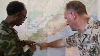 Deutscher und malischer Soldat schauen auf eine Landkarte