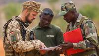 Deutscher Soldat mit malischen Soldaten im Gespräch