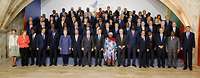 Angela Merkel und weitere internationale Politiker stehen in mehreren Reihen für ein Gruppenbild.