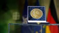 Die Manfred-Wörner-Medaille in einem Etui steht auf einem Podest