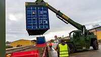 Container hängt im LogHub für den Umschlag zwischen Straße und Schienenfahrzeugen an einem Containerstapler.