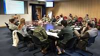 Soldaten und Zivilisten an Konferenztisch