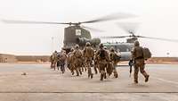 Soldaten steigen in einen Hubschrauber vom Typ Chinook