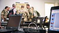 Laptop und Technik vor Soldatenim Hintergrund
