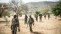 Malische Soldaten laufen mit ihren Waffen zur Schießausbildung