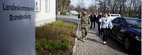 AKK und Soldaten laufen zum Eingang des Landeskommandos Brandenburg