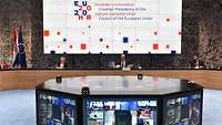 Drei Personen sitzen in einer Videokonferenz der Europäischen Union