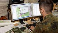 Ein Soldat bearbeitet eine geografische Karte am Computer