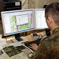 Ein Soldat bearbeitet eine geografische Karte am Computer