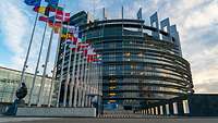 Flaggen verschiedener Nationen wehen am Mast vor dem Glasgebäude des Europäischen Parlaments