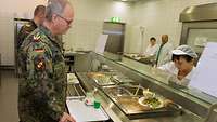 Generalinspekteur Zorn steht an der Essenausgabe in der Truppenküche