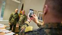 Soldat macht ein Foto von Zorn und Sascha Mies mit dem Handy