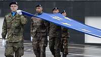 Mehrere Soldaten halten die Flagge der Europäischen Union.