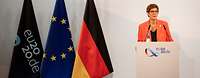 Kramp-Karrenbauer spricht am Rednerpult vor weißer Wand mit Logo eu2020.de, neben ihr Flaggen von Deutschland, EU, eu2020