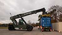 Kranfahrzeug hebt einen Container vom LKW