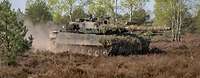 Kampfpanzer Leopard fährt durch ein Gelände