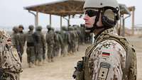 Ein deutscher Soldat beobachtet afghanische Soldaten, die in einer Schlange stehen