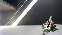 Ein Blumengesteck liegt im Raum der Stille im Ehrenmal der Bundeswehr