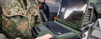 Ein Bundeswehrsoldat hält einen Laptop