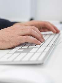 Männliche Hände tippen auf einer Tastatur