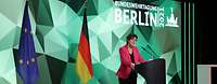 Kramp-Karrenbauer am Rednerpult vor Polygon-Wand mit Text "Bundeswehrtagung Berlin 2021" und Flaggen von EU und Deutschland