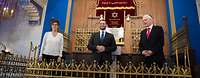 Ministerin Kramp-Karrenbauer steht mit zwei Männern in einer Synagoge vor einem Altar