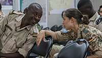 Eine deutsche Soldatin im Gespräch mit einem senegalesischen Soldaten