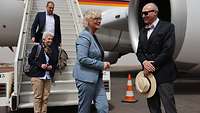 Ministerin Lambrecht wird von Botschafter Pohl vor einem Flugzeug begrüßt 