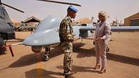 Verteidigungsministerin Lambrecht steht mit einem Soldaten vor der Drohne Heron 1