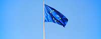 Die Europaflagge weht im Wind vor hellblauem Himmel.