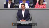 Staatssekretär Hitschler steht an einem Pult im Bundestag und spricht.