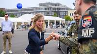 Staatsekretärin Möller verabscheidet sich von einem Soldaten der Feldjäger mit einem Faustgruß