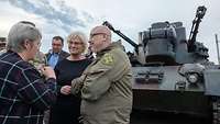 Ministerin Lambrecht steht vor einem Panzer des Typ Gepard und spricht mit einem Soldaten.