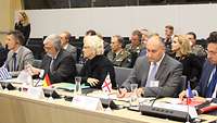 Ministerin Lambrecht sitzt mit anderen Personen an einem Tisch während einer Konferenz