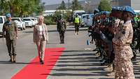 Verteidigungsministerin Lambrecht schreitet auf einem roten Teppich an internationalen UN-Soldaten vorbei.