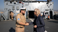 Auf dem Deck einer Korvette begrüßt Verteidigungsministerin Lambrecht den Kapitän mit einem Händedruck. 