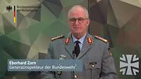 General Zorn steht vor einer Wand mit dem Polygonemuster der Bundeswehr