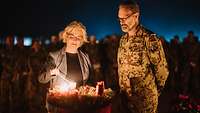 Zusammen mit einem Soldaten zündet Christine Lambrecht Kerzen an einem Adventskranz an.