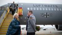 Christine Lambrecht wird von einem Stabsoffizier vor einem Flugzeug der Luftwaffe in Empfang genommen