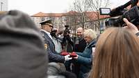 Christine Lambrecht steht neben dem slowakischen Verteidigungsminister und bekommt einen Symbolischen Schlüssel überreicht.