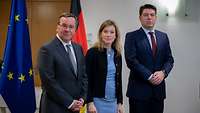 Minister Pistorius Siemtje Möller and Thomas Hitschler, stand side by side in front of the federal service and European flags