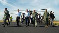 Boris Pistorius, Jens Stoltenberg und der Leiter des Kommandos Luftwaffe, sowie weitere Personen laufen auf einem Flugfeld.