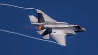 Ein Kampfflugzeug Lockheed Martin F-35 Lightning II (F-35A) fliegt vor blauem Himmel.