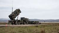 The Patriot anti-aircraft missile system is located in the field.