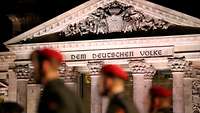 Soldaten (unscharf) vor dem Reichstag mit der Inschrift „Dem deutschen Volke“