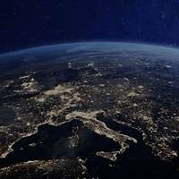 Der obere Teil der Erde mit Europa ist aus dem All abgebildet. Viele Lichter strahlen von Europa aus.