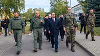 Boris Pistorius läuft gemeinsam mit weiteren Soldaten und Personen über eine Straße.