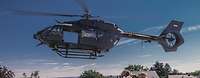 Ein Hubschrauber vom Typ H145M fliegt dicht über einer Gruppe Soldaten auf einem Dach.