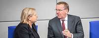 Eva Högl und Boris Pistorius sitzen im Bundestag und unterhalten sich miteinander.