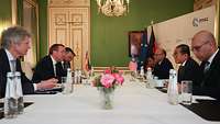 Boris Pistorius sitzt mit Mohamed Khaled Nordin und weiteren Personen an einem Tisch